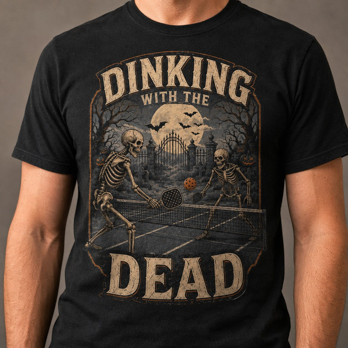 WearTheJoke.com black cotton t-shirt featuring a vintage skeleton pickleball graphic with a spooky Halloween theme.